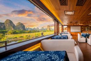 a train car with beds and a view of mountains at Li River Gallery Lodge in Yangshuo