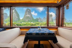 a table in a room with a view of mountains at Li River Gallery Lodge in Yangshuo