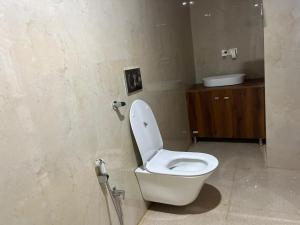 a bathroom with a white toilet and a sink at HOTEL SHAILJA & AD CONTINENTAL RESTAURANT in Joshīmath