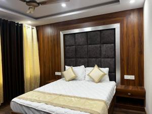 a bedroom with a large bed with a black headboard at HOTEL SHAILJA & AD CONTINENTAL RESTAURANT in Joshīmath