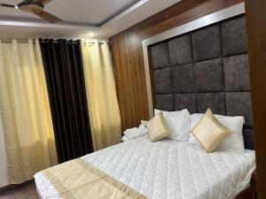 a bedroom with a large bed with white sheets and pillows at HOTEL SHAILJA & AD CONTINENTAL RESTAURANT in Joshīmath