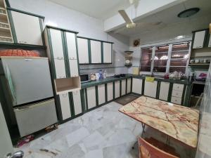 a kitchen with a counter and a table in it at Al-Bayt Homestay in Ayer Keroh +3 photos