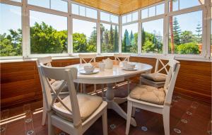 uma sala de jantar com mesa, cadeiras e janelas em Villa Santa Rosa, Mijas Golf em Mijas Costa