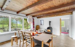 uma cozinha e sala de jantar com uma mesa e um fogão a lenha em Pet Friendly Home In Snedsted With House A Panoramic View em Snedsted