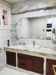 łazienka z umywalką i dużym lustrem w obiekcie Villa Lorangeraie, Wilaya de Tlemcen w mieście Tilimsan