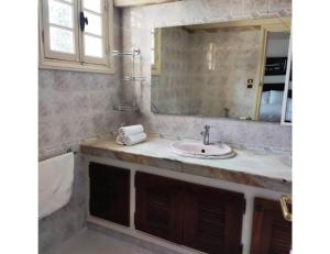 W łazience znajduje się umywalka i lustro. w obiekcie Villa Lorangeraie, Wilaya de Tlemcen w mieście Tilimsan