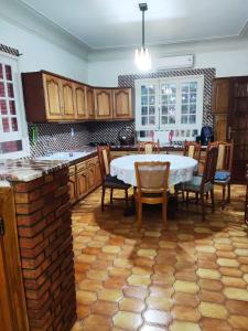 una cocina con mesa y sillas. en Villa Lorangeraie, Wilaya de Tlemcen, en Tlemcen