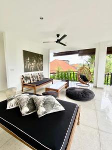 a living room with two beds and a ceiling fan at The Villas Umalas in Canggu