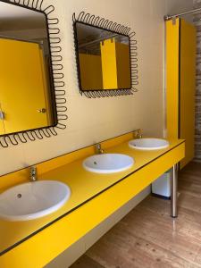 un bagno con due lavandini e uno specchio di Albergue La HERMIDA a La Hermida Altre 31 foto