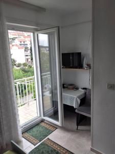 a room with a sliding glass door leading to a balcony at Apartment and rooms Hvar Limoni accessible today in Hvar