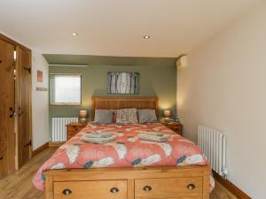 a bedroom with a bed with a wooden dresser at The Pheasant's Nest in Welland