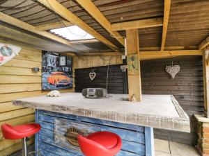 a kitchen with a counter and two red stools at The Pheasant's Nest in Welland