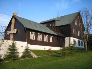 un granero marrón grande con techo verde en Hotel-Penzion Johanka en Háj