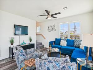 een woonkamer met blauwe banken en een flatscreen-tv bij Beach Rays in Galveston
