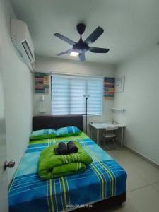 een slaapkamer met een bed met groene lakens en een plafondventilator bij Da Best Guesthouse One Maxim Sentul Nice Cozy Condo 3 Rooms Aircond in Sentul KL in Kuala Lumpur
