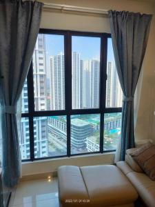 a living room with a large window and a couch at Da Best Guesthouse One Maxim Sentul Nice Cozy Condo 3 Rooms Aircond in Sentul KL in Kuala Lumpur