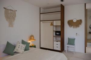 a bedroom with a bed with a mirror and a chair at The Bed by The Sea in Canggu