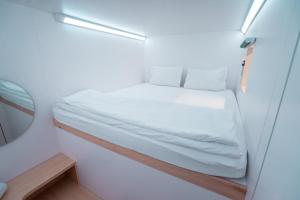 1 dormitorio pequeño con 1 cama en una habitación pequeña en Bobopod Kebayoran Baru, Jakarta, en Yakarta