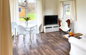 uma sala de estar com uma mesa e cadeiras e uma televisão em Beautiful Home In Ssel With Kitchen em Süsel