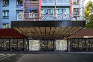 a building with a balcony on top of it at Yiwu Manting Hotel International Trade City义乌漫庭酒店 in Yiwu