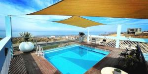 a swimming pool on a balcony with a view of the ocean at Capitan Boutique Resort in Puerto Nuevo