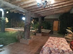 a patio with a table and a chandelier at Casa de campo in Rodeo del Medio