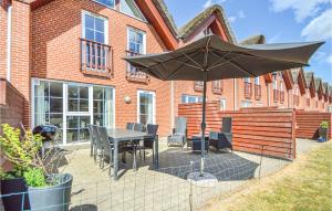 a patio with a table and an umbrella in front of a building at Awesome Home In Rm With 3 Bedrooms And Wifi in Bolilmark