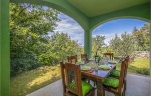 een eettafel op een patio met uitzicht op de tuin bij Pet Friendly Home In Crikvenica With Wifi in Crikvenica