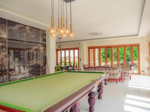 una mesa de billar en una sala de estar con piscina en Nichahome Luxury Villa en Hua Hin