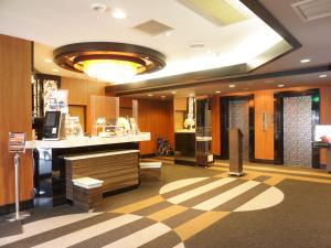 een lobby van een hotel met een balie en een kamer bij APA Hotel Saitama Yatsuka Ekimae in Soka