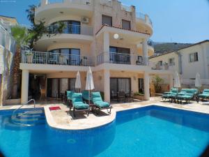 a building with a swimming pool in front of a house at Truffle Residences in Kalkan