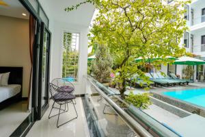 Habitación con vistas a la piscina, cama y árbol en Banana Garden Villa, en Hoi An