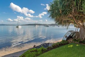 a view of a beach with boats in the water at Selby Cottage - Intimate Waterfront Getaway in Marks Point