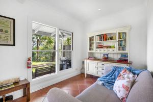 a living room with a couch and a window at Watta Cottage in Wattamolla