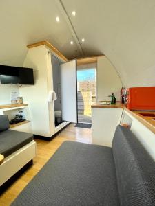 a kitchen and a living room with a couch and a table at Armadilla 2 at Lee Wick Farm Cottages & Glamping in Clacton-on-Sea
