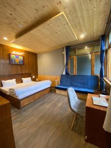 sypialnia z 2 łóżkami i niebieską kanapą w obiekcie Lacasa Luxury Stays w mieście Shogi