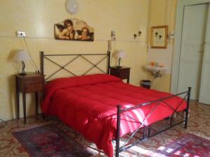 a bedroom with a red bed and a sink at B&B Il Vecchio Messina in Trapani