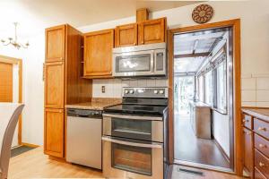 a kitchen with a stove and a microwave at Blissful Retreat in Wisconsin Rapids in Wisconsin Rapids