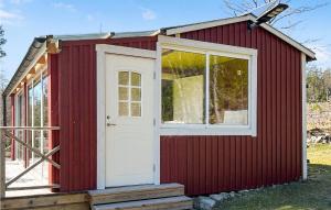 ein rotes winziges Haus mit weißer Tür in der Unterkunft Amazing Home In Gunnebo With House Sea View in Gunnebo
