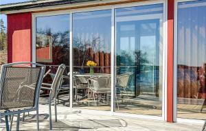 eine Terrasse mit Stühlen und einem Tisch vor einem Fenster in der Unterkunft Amazing Home In Gunnebo With House Sea View in Gunnebo