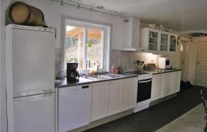 a kitchen with white cabinets and a sink and a window at Amazing Home In Ryssby With 1 Bedrooms, Sauna And Wifi in Hörda