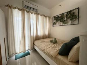 um quarto com uma cama e uma janela com cortinas em Casa Feliz - Greenfield em Manila