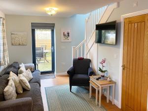 a living room with a couch and a chair and a table at Coachmans Cottage - Ukc2773 in Sandwich