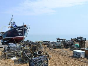 a boat sitting on top of a beach with nets at Coachmans Cottage - Ukc2773 in Sandwich