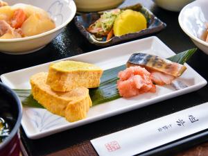 YOU STYLE HOTEL HAKATA في فوكوكا: طبق من الطعام مع السوشي على طاولة
