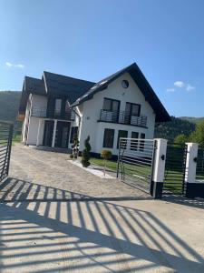 une maison avec une clôture et un banc devant elle dans l'établissement Vila Lorena, à Stejaru