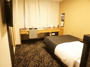 Postel nebo postele na pokoji v ubytování APA Hotel Saitama Yatsuka Ekimae