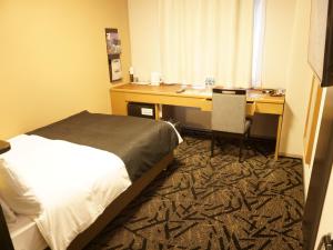 A bed or beds in a room at APA Hotel Saitama Yatsuka Ekimae