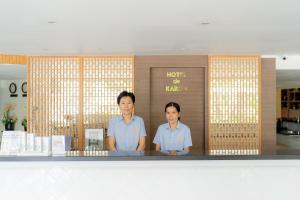 two men standing in front of a counter at Hotel De Karon in Karon Beach