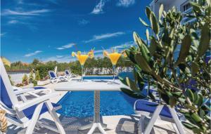 a pool with two martini glasses on a table with chairs at Five-Bedroom Holiday Home In Zadar in Zadar +50 photos